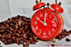 Kaffee-ist-gesund-und-macht-munter-Beispielbild-mit-Kaffeebohnen-und-Wecker