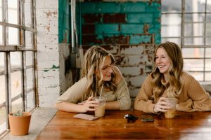 Kaffee-macht-gl-cklich-Beispielbild-Zwei-junge-Frauen-trinken-Kaffee-und-lachen